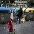 Una mujer deposita residuos en contenedores.