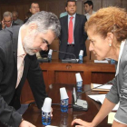 Fernando Álvarez consulta una duda con la secretaria municipal, con la bancada del PP al fondo.