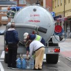 Vecinos de Fabero aprovisionándose de agua de una cuba cisterna, este jueves. L. DE LA MATA