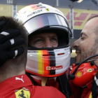 Sebastian Vettel es felicitado por dos de sus mecánicos tras lograr su tercera pole consecutiva de la temporada.
