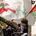 Un niño libanés sentado junto a un cohete durante una manifestación de seguidores de Hamas.