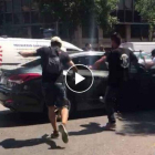 Manifestantes durante la huelga de taxis en Barcelona atacan un coche de Cabify /