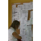 Una mujer parada observa ofertas de empleo.