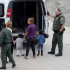 Oficiales migratorios de los EEUU detienen a una mujer y sus hijos.