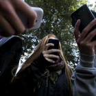 Un grupo de adolescentes utilizan sus teléfonos móviles.