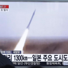 Un hombre sigue por televisión el lanzamiento del misil.