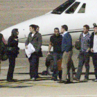 William, con jersey azul y Harry, con camisa a cuadros, en el aeropuerto.