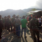 Fotografía cedida por la Estación de Policía del municipio de Carranglan donde se ve a ciudadanos filipinos, soldados y policías sosteniendo una cuerda para recuperar los cuerpos de las víctimas del accidente.