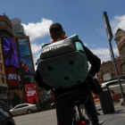 Un rider de Deliveroo realizando su reparto en su bicicleta.