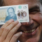 El gobernador del Banco de Inglaterra, Mark Carney, muestra el nuevo billete de plástico de 5 libras.