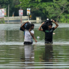 Dos jóvenes caminan entre las aguas a unos 17 kilómetros de la capital de Sri Lanka, Colombo.