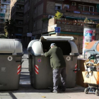 Un hombre recoge basura en unos contenedores