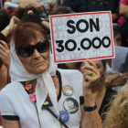Una mujer sostiene un cartel en referencia a los 30.000 desaparecidos mientras escucha el veredicto por los crímenes cometidos en la ESMA, en Buenos Aires, el 29 de noviembre.