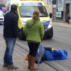 Un ciclista herido en un accidente permanece tendido en la calle Camino de Santiago, en Ponferrada, mientras llegan los servicios médicos