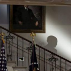 La sombra de Obama mientras se dirige hacia el gran vestíbulo de la Casa Blanca.