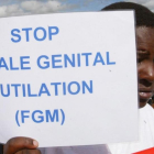 Una mujer sostiene una cartel contra la Mutilación Genital Femenina en una protesta en Kenia.