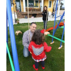 La pequeña, con sus padres en el jardín de su casa donde tiene todos los juegos.
