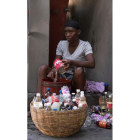 Una mujer haitiana llena botellas con gasolina para vender. ORLANDO BARRIA