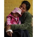 Mariella, en los brazos de su madre Kaythy de La Cruz, en su casa de Lima.