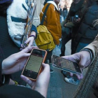 Unos jóvenes consultan sus teléfonos móviles en un instituto de Barcelona.