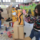 Una de las alumnas da forma a su obra, sobre una de las cajas dispuestas en el recinto.