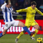 El delantero italiano del Villarreal, Rossi, conduce el balón presionado por el donostiarra Rivas.