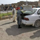 Un policía afgano revisa el vehículo de un ciudadano en una vía de Herat.