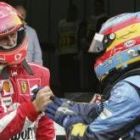 El piloto alemán Michael Schumacher saluda al español, líder del Mundial, Fernando Alonso