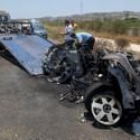 Dos operarios retiran los restos de uno de los coches accidentados