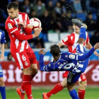 El delantero uruguayo del Alavés Diego Rolan remata ante el centrocampista del Girona Alex Granell.