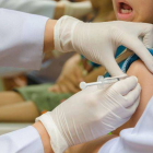 Una enfermera suministra una vacuna a un niño.