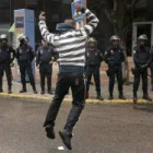 Un manifestante frente al cordón policial en la sede de la Policía Local de Coslada