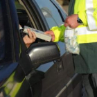 Un agente de la Guardia Civil realiza la prueba de alcoholemia a un conductor.