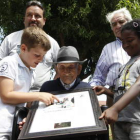 Los biznietos del señor Quico ayudan a su abuelo a localizarse en el cuadro con el que Pinilla homenajea a su supercentenario.