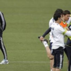 El técnico José Mourinho, pasa junto a varios de sus jugadores, durante el entrenamiento de ayer.