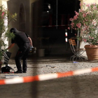 Un agente examina la mochila en la que el autor del ataque llevaba los explosivos, frente a un restaurante de Ansbach (Alemania), este domingo.