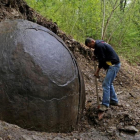 Suad Keserovic limpia la esfera de piedra en Podubravije, cerca de Zavidovici (Bosnia), el 11 de abril.
