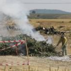 Un operario contratado por la Junta atiende ayer a mediodía la pira situada en un paraje de Tendal