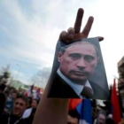 Un ciudadano serbio de Kosovo alza una imagen de Putin junto al signo de la victoria