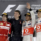 El británico de McLaren Mercedes, Lewis Hamilton, celebra en el podio la victoria conseguida en el Gran Premio de Abu Dabi junto a Alonso y a Button.