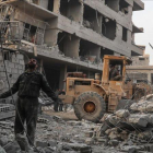 Civiles y voluntarios de la Defensa Civil Siria buscan sobrevivientes tras varios ataques aéreos en la ciudad de Hamoria, en Guta.