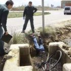 Dos guardias civiles observan el cadáver del ciclista accidentado en las cercanías de Palencia