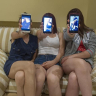 Laura (centro), junto a dos amigas, muestran una foto tomada por la aplicación Snapchat en sus móviles.