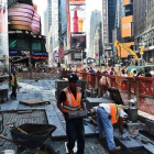 Empleados trabajan en obras de una acera y carretera en Times Square (New York).