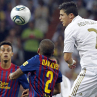 Cristiano Ronaldo intenta rematar la pelota en presencia del defensa brasileño del Barcelona, Dani Alves, y ante la mirada de Thiago.