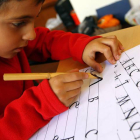Un niño escribe en un taller de caligrafía