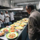 Antonio Puig y el subdelegado observan los platos realizados por los internos.
