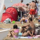 Una mujer en 'burkini', junto a su familia, en la playa de Roses.