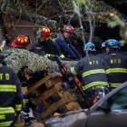 Los equipos de rescate retiran el árbol caído sobre una casa que provocó dos muertos. JIM LO SCALZO