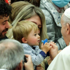 El papa le pone el chupete a un bebé, durante la celebración ayer de la audiencia semanal en el Vaticano. GIUSEPPE LAMI